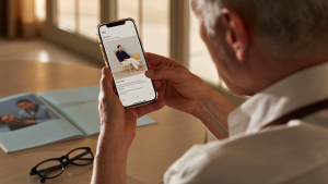 Homem de meia idade afastando o celular para ler, sinal de vista cansada após os 40 anos